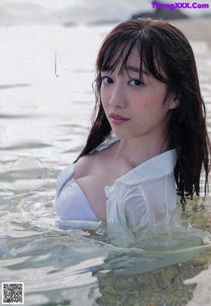 A woman in a pink bikini standing in the water.