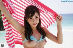 A woman in a blue and white striped bikini holding a red and white towel.