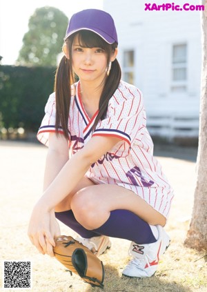 A woman in a baseball uniform throwing a ball.