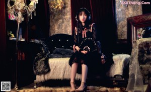 A woman in a black dress standing in a room.