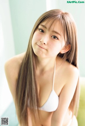 A woman with long brown hair wearing a pink bra.