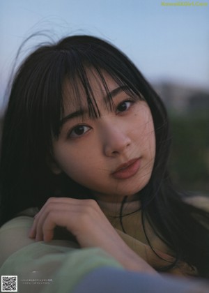 A woman with long black hair smiles at the sky.