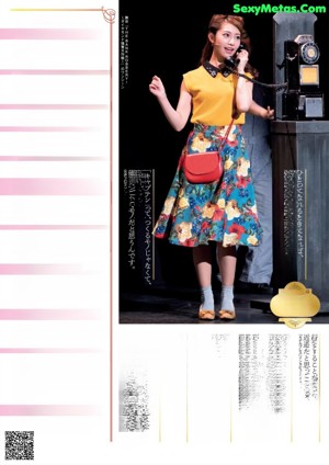 A woman in an orange top and a floral skirt.