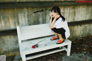 A woman in a red kimono sitting on the floor.