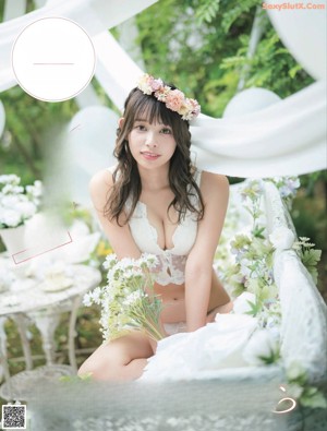 A woman sitting on a chair with a flower crown on her head.