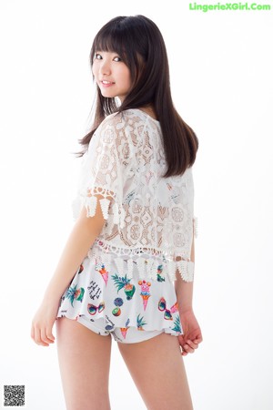 A young woman sitting on the floor with her legs crossed.
