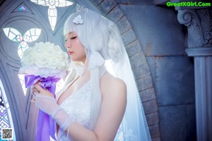 A woman in a wedding dress standing in front of a stained glass window.