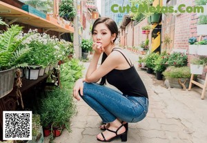 A woman standing in front of a flower shop.