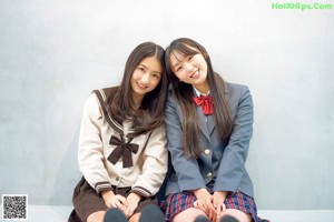A couple of young women sitting next to each other.