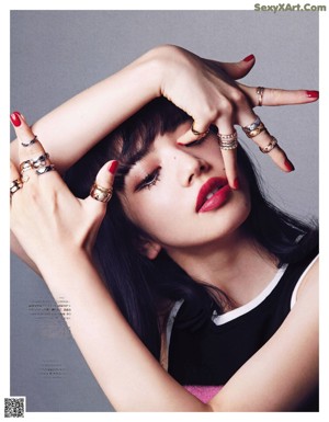 A woman with long black hair and a ring on her finger.