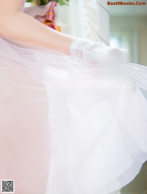 A woman in a wedding dress holding a bouquet of flowers.