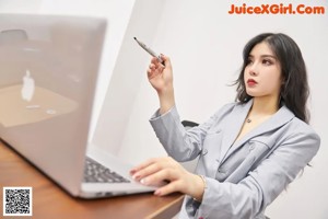 A woman sitting on top of a dresser smoking a cigarette.